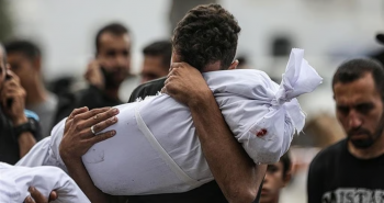 مواطن يحتضن طفله خلال تشييع شهداء في غزة